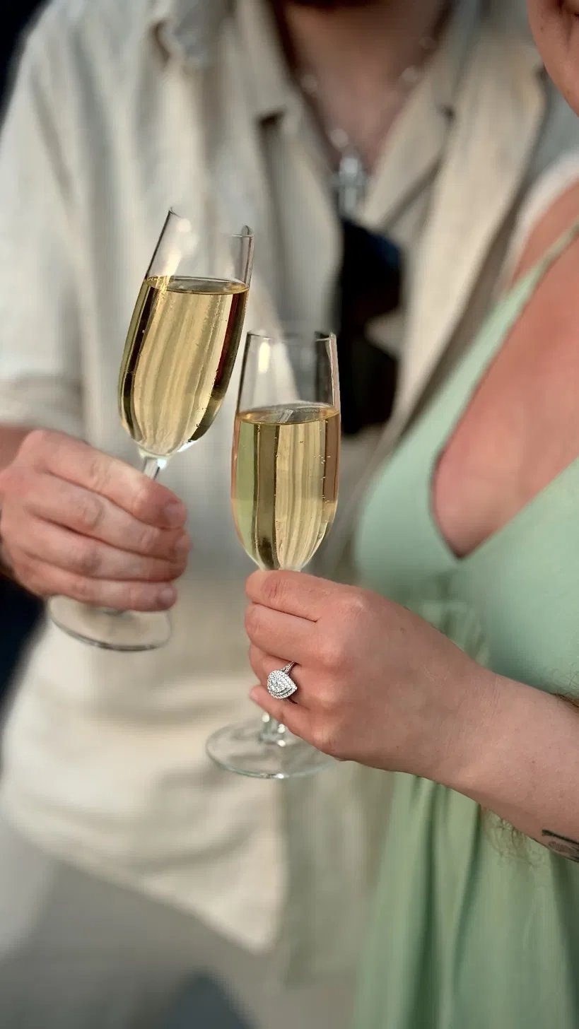Champagne toast showing off a new engagement ring