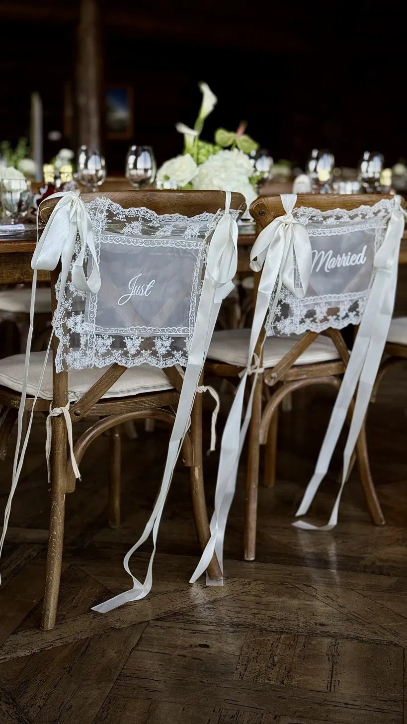 Just Married lace signs tied to the newlyweds' chairs