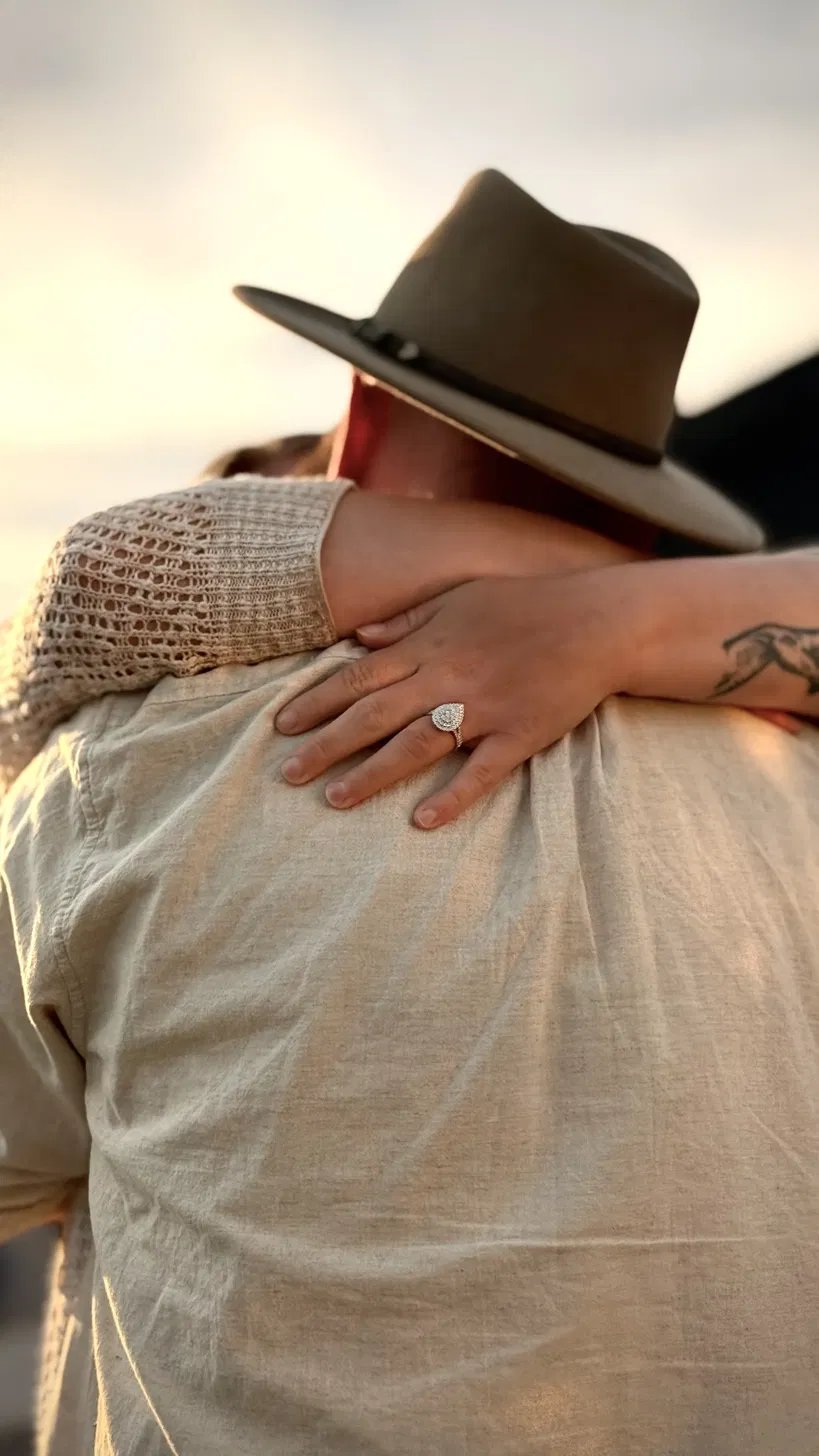 A couple embracing on the shore at golden hour