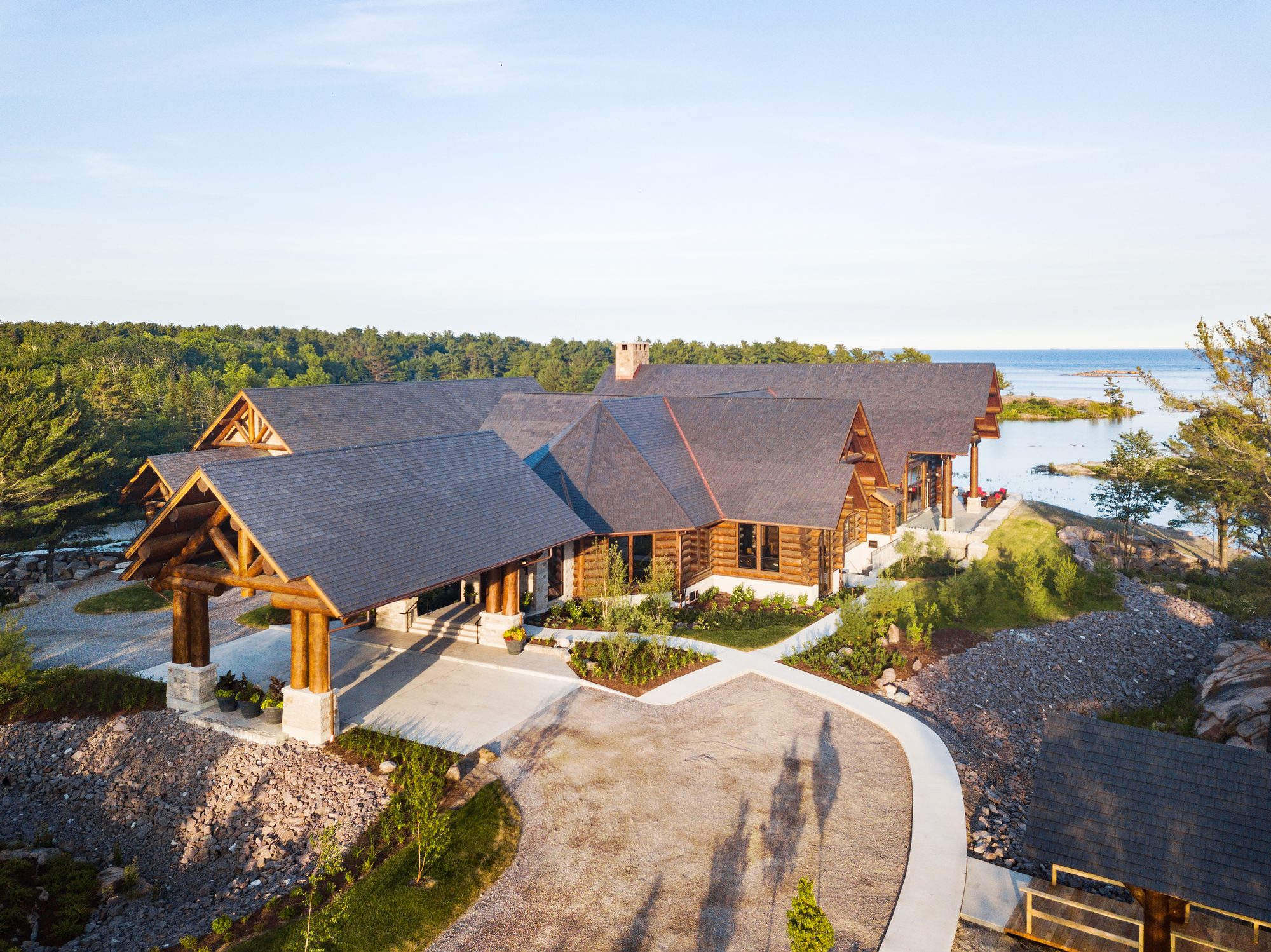 Aerial view of the log porte-cochère entrance at golden hour
