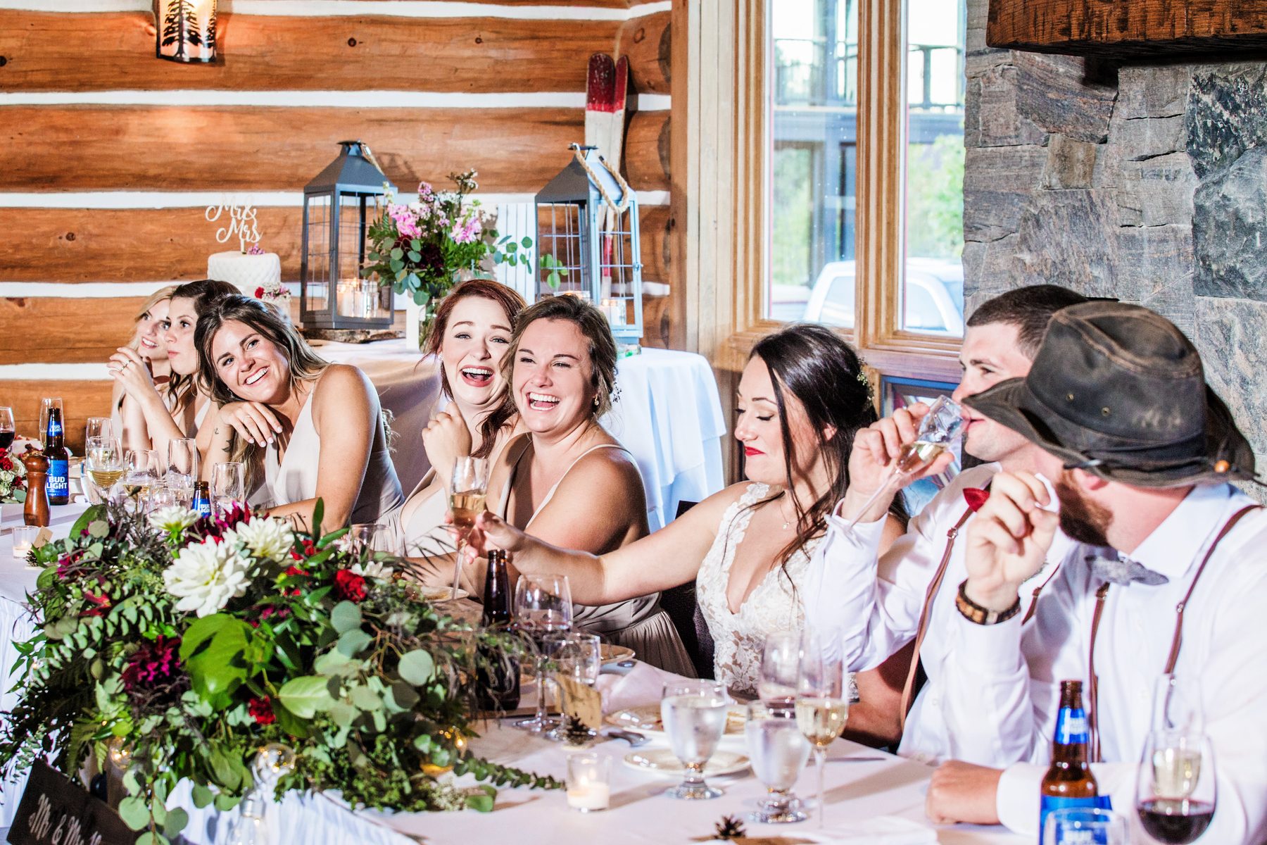 Bridesmaids laughing and raising glasses at the reception table