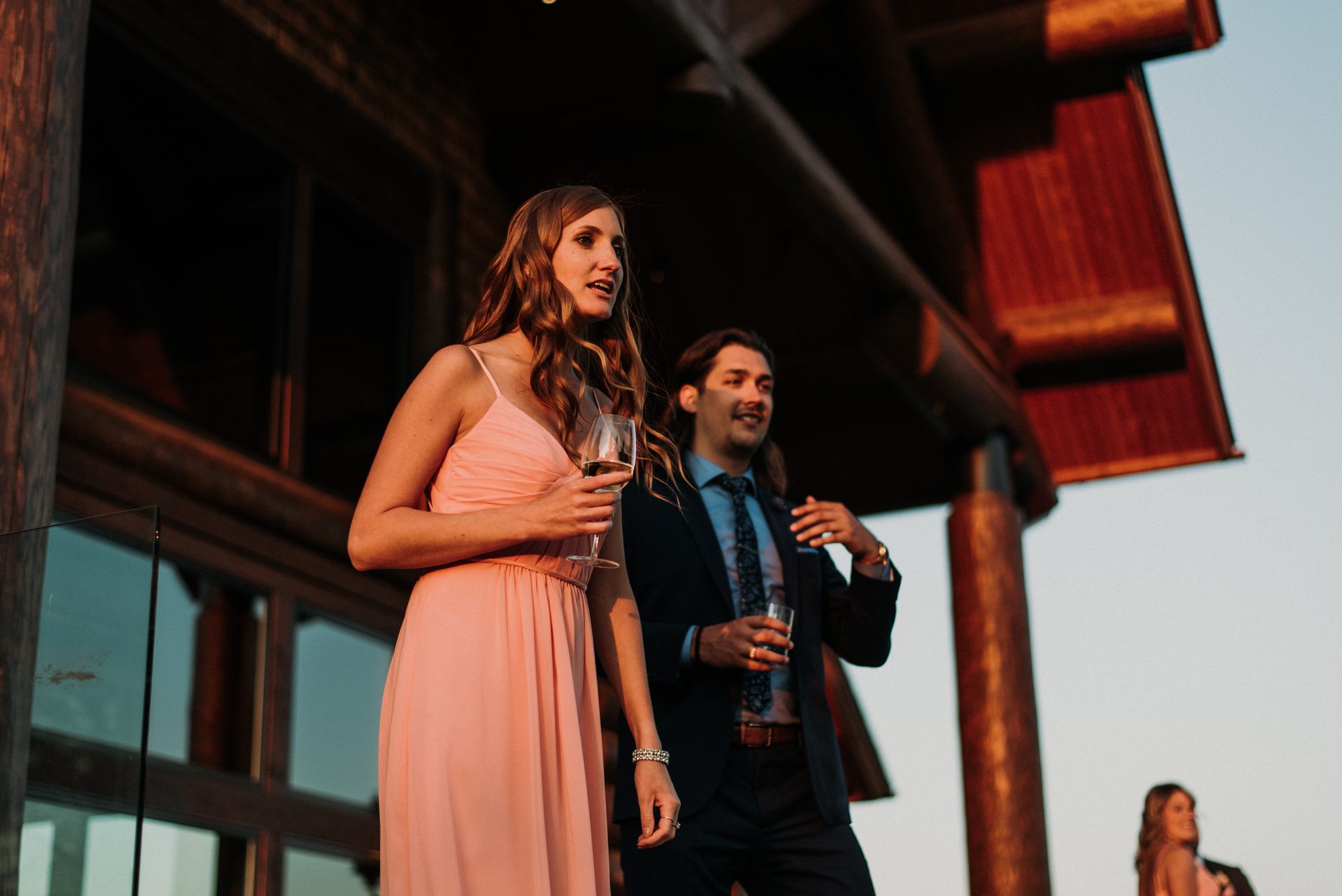 Guests toasting with wine in the warm evening light outside the lodge
